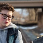 Carson Ferris passionately playing guitar outdoors.