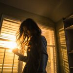 Woman with Long Black Hair in Room with Sunset Through Window