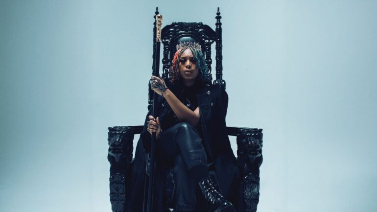 Artist Forever The Rebel seated on a gothic throne holding a scepter.