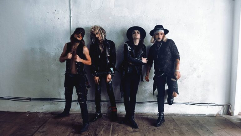 Band Wildstreet posing against a white wall in rock attire for "Sick To Death".