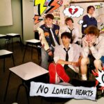 Band members of No Lonely Hearts posing in a classroom with 'Better Than Me' doodles.