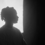 Silhouette of a person in profile against a window light.