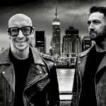 DJ Remo and Robbie Hutton in front of city skyline