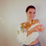 Estella Dawn posing with flowers in a soft focus, promoting her new song "514 Denim."