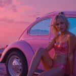 AI generated woman in a pink bikini sits against a pink vintage car on a beach at sunset, reflecting the vibrant and playful vibe of Other Gods' new song 'Games'.