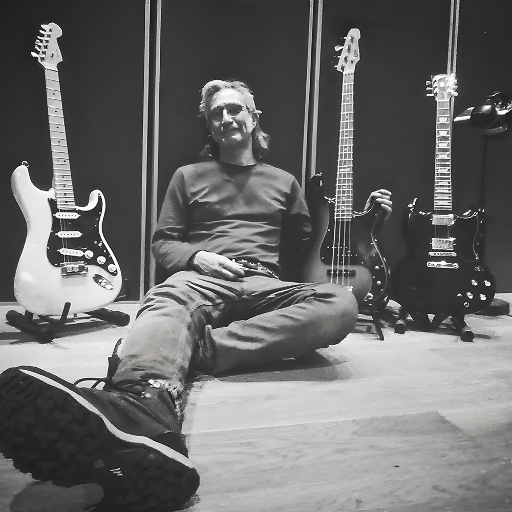 Renato Anesi sitting with his guitars in the studio