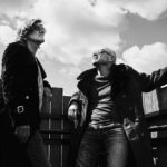 Bil&Gin, the Brussels-based DJ duo, pose against a backdrop of clouds, highlighting their eclectic and innovative music style.