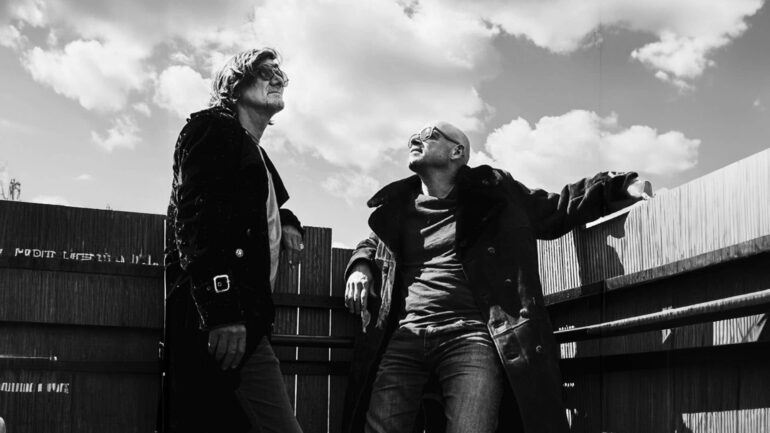 Bil&Gin, the Brussels-based DJ duo, pose against a backdrop of clouds, highlighting their eclectic and innovative music style.