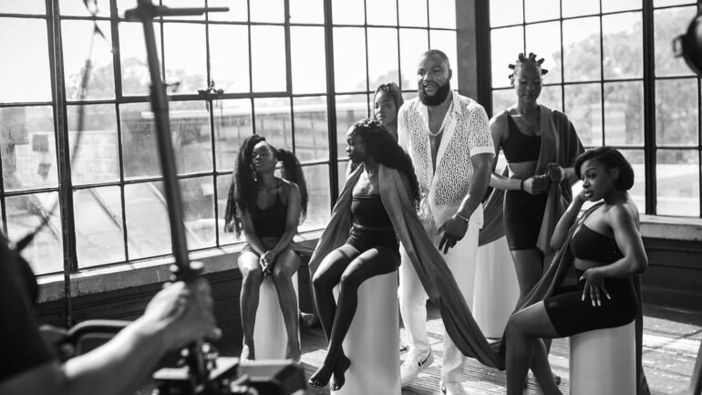 Joey Jaey poses with models in a studio setting during the promotion of his new single Obi Kererenke.