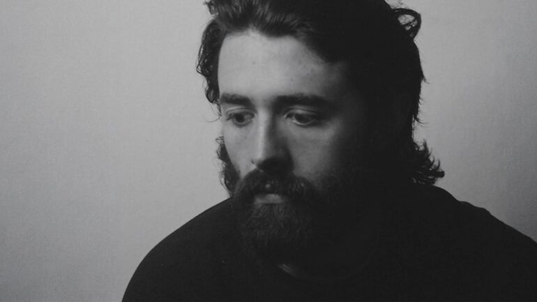 Face and the Features 'COLD' single cover featuring a monochrome portrait of the artist, Tristan de Beer, looking downwards with a pensive expression.