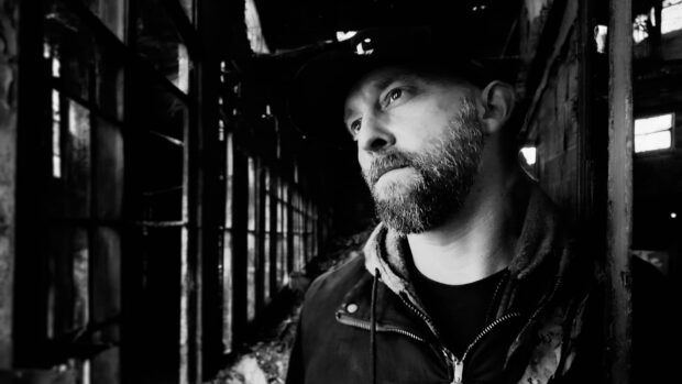 Kelly Murphy in an abandoned warehouse with intense expression.