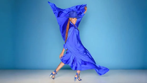 Rhona Bennett dances in a flowing blue dress, expressing joy and emotion.